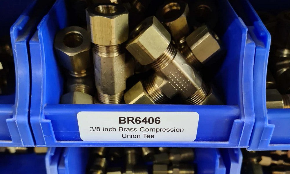 Brass fittings in blue plastic display boxes with a product tag.