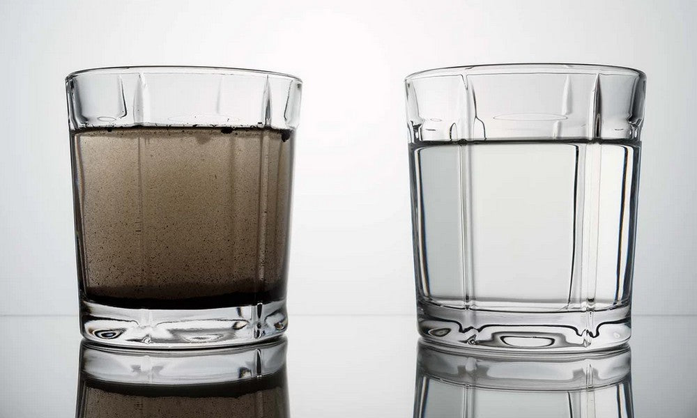Two glasses of water side by side, on the left dirty water and on the right clear clean water.