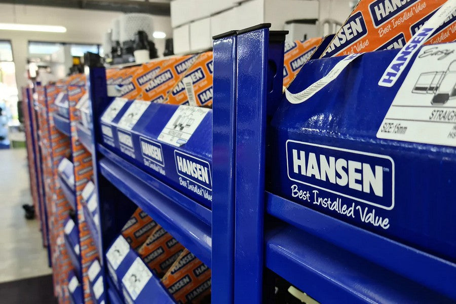 A row of blue containers labeled 'Hansen' that hold plastic fittings. 