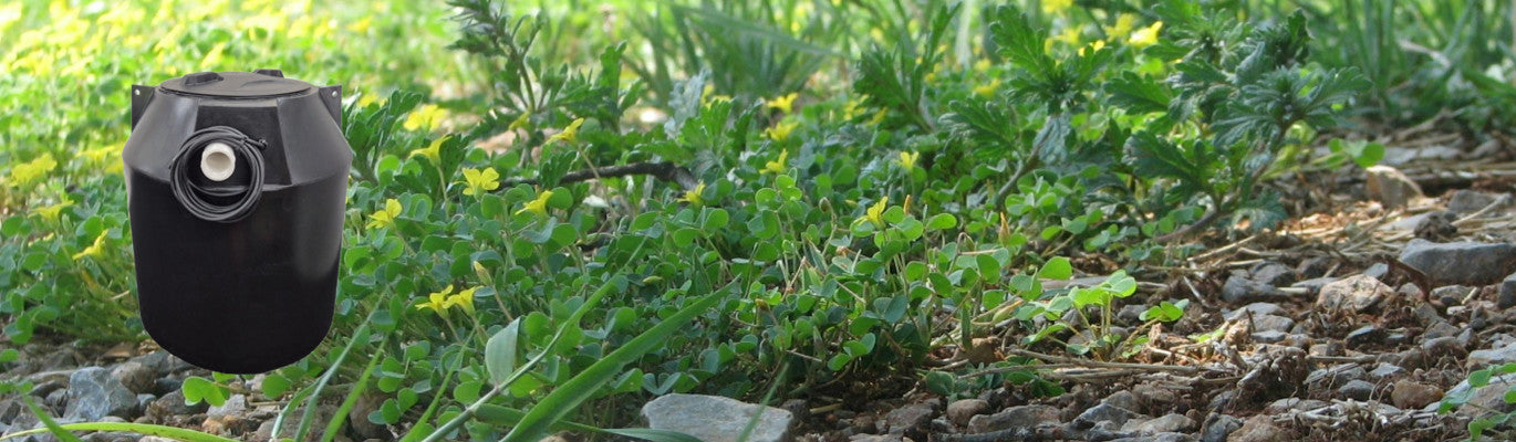 Black plastic pump chamber on a background of grass and stones