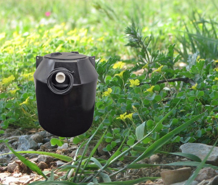 Black pump chamber on background of greenery and stones